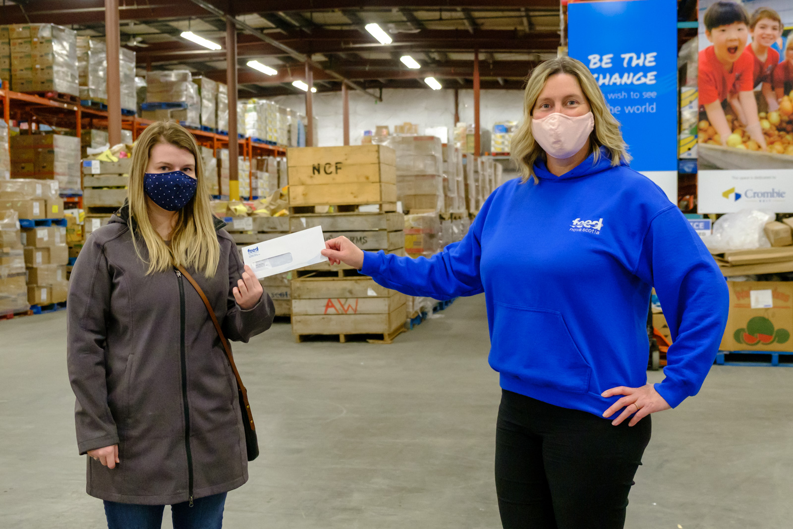 Feed Nova Scotia staff member presenting prize envelope to winner