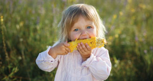 Little girl eating corn on the cob