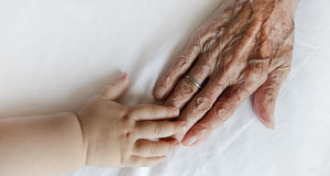 grandmother's hand touching her grandchild's hand