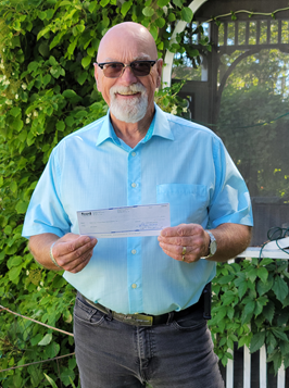 person holding cheque and smiling