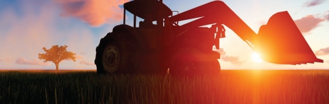 farm tractor in a field at sunrise