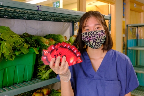 Food bank volunteer holding grocery gift cards