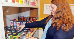 Woman stacking cans of food on a shelf