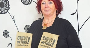 Woman holdling paper bags bearing a campaign logo