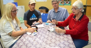 Four volunteers sitting around a table looking at naloxone kits