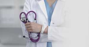 woman in a lab coat holding a stethoscope