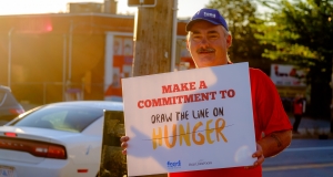 Man holding a placard about hunger awareness