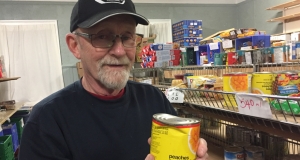 Robert Dolomont holding a dented can of peaches