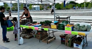 A table filled with food and a women serving a young child and a mean