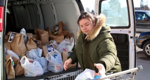 person loading shopping bags into the back of a cube van